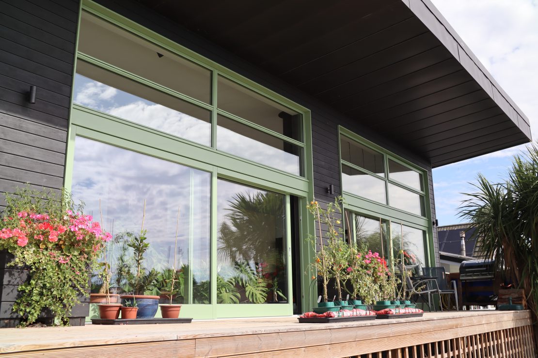 Riverside house with green sliding doors opening onto the River.