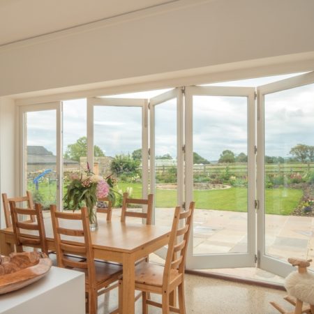 picture of a large set of bifold doors in a kitchen with the countryside in the difference