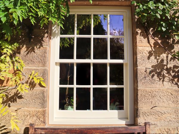 spiral balance sliding sash window with putty glazing painted in cream paint