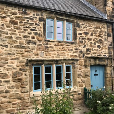 Yorkshire sliding sash windows painted blue set in a traditional stone cottage in Jarrow, County Durham