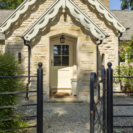 traditional style cream wooden front door in a stone cottage with four panel glazing and astragal bars