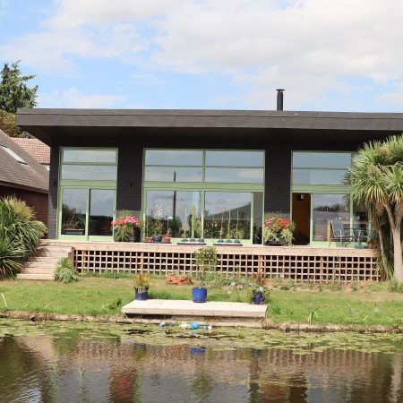 black contemporary house with green timber sliding doors