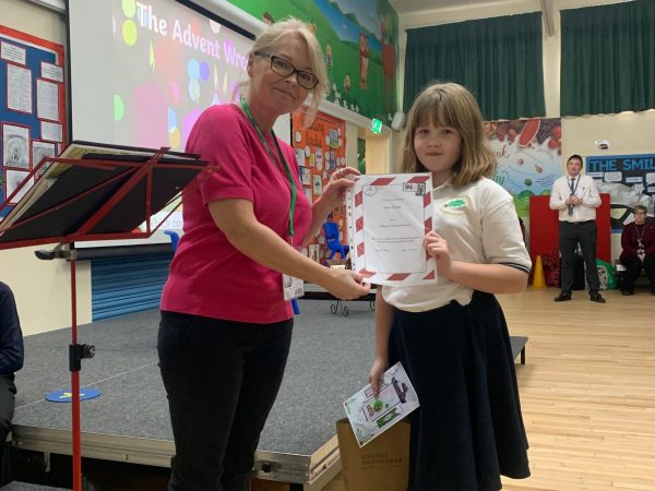 Lucy Young winner of Christmas card competition receiving her prize from tracy Pomfret