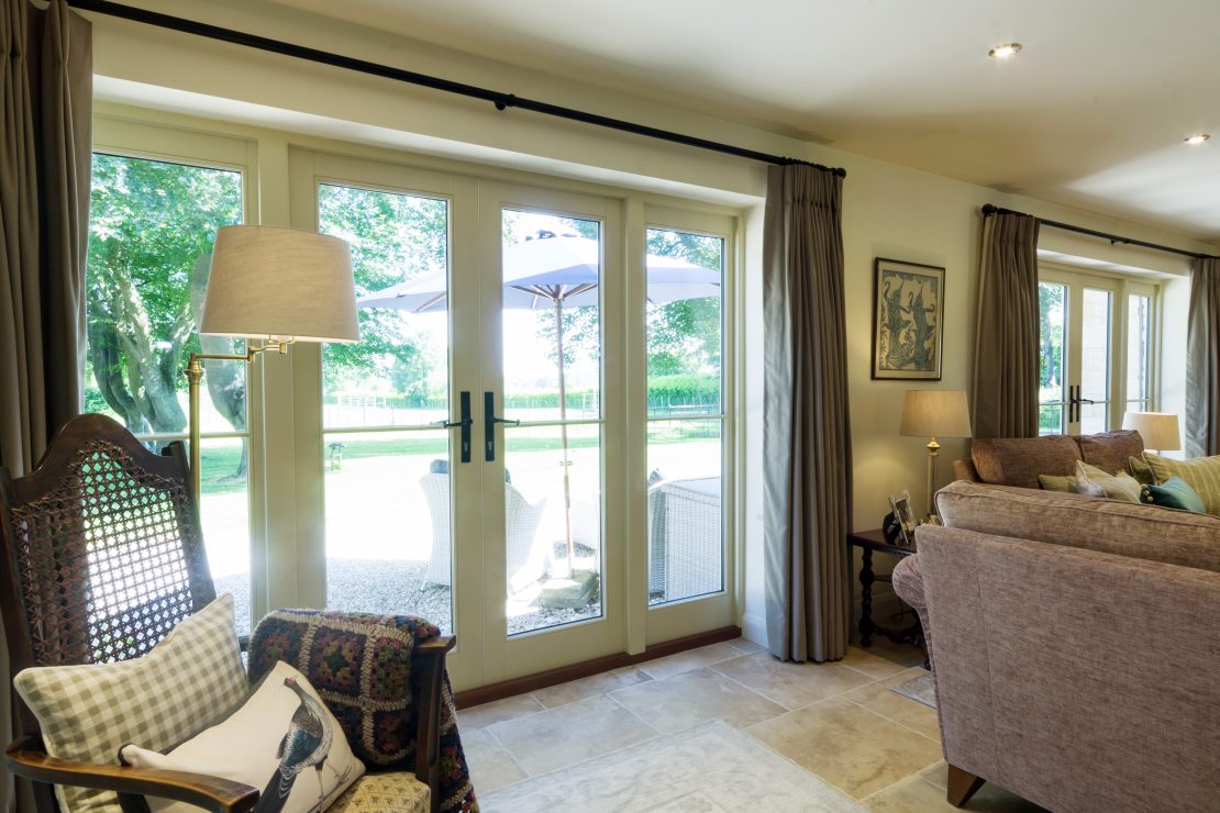 set of timber french doors in living room painted in white with a single glazing bar