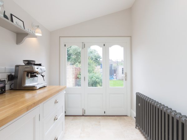 part glazed, part panelled timber bifold door made to match traditional french doors