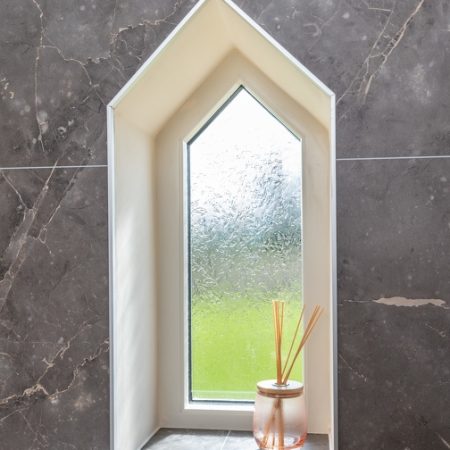 small pentagon shaped window with obscure glass in a bathroom