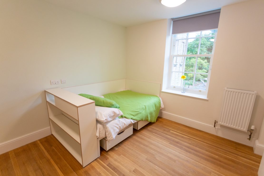 Student bedroom with bed in front of timber sliding sash window at Florence Boot Hall