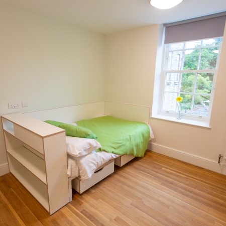 Student bedroom with bed in front of timber sliding sash window at Florence Boot Hall