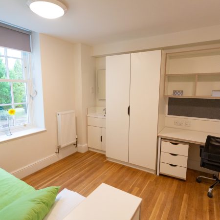 Student bedroom with desk, sink and sliding sash window