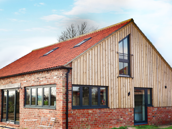 former Yorkshire Piggery converted into a residential property with timber windows and doors painted in dark grey