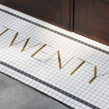 tiled Threshold to twenty Berkeley Square London showing the number twenty spelt out in gold on white mosaic tiles