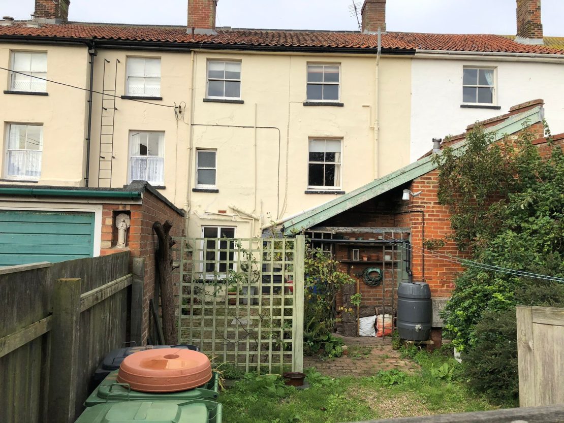 rear of a Victorian townhouse property with old sliding sash windows and a lean-to awaiting renovation 