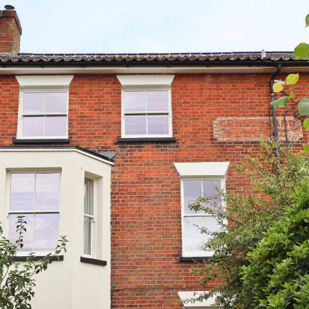 front external shot of top two floors with sliding sash bay window and two smaller sash windows above